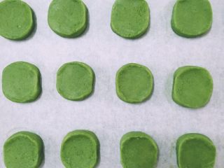 9、【网上厨房独家】微苦抹茶沙布列酥饼,取出面团外面洒上适量的砂糖作为装饰，切成厚大约1cm的小饼，放入铺好油纸的烤盘中