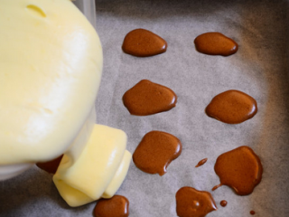 17、奶牛蛋糕卷,将蛋糕糊倒入定型的可可糊烤盘上。