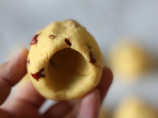 10、红枣奶香窝头,用大拇指一边在面团上钻洞，一边转动面团。