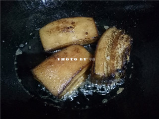 7、四川烧白,放入五花肉，炸至表面焦黄（厨房光线较暗，看起来像炸糊了，但其实并不是）；