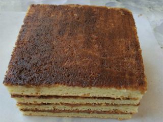 16、欧培拉歌剧院蛋糕,将四片蛋糕以奶油馅蛋糕层，甘纳许蛋糕层，奶油馅蛋糕层的次序摞起来，最后一片也是奶油馅蛋糕层