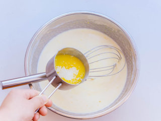 4、千层蛋糕,直至所有牛奶加完混合均匀后,倒入融化黄油,拌匀