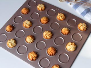 12、花样黄油曲奇,把烤盘放入预热好的烤箱中层，因为两种造型的曲奇厚度不一，所以烘烤是时间也不同，2D花嘴挤出来的曲奇烘烤时间是12分钟左右，4B花嘴挤出来的曲