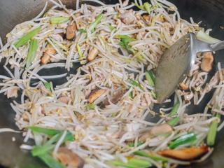 8、豆芽炒鸡肉,鸡肉再回锅转大火。再翻炒10秒钟，混合所有的菜，绿豆芽炒出水的时候，把玉米淀粉兑水倒进锅里。再炒15秒。