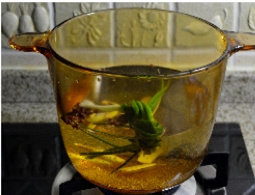 2、翡翠玉兔,煮锅放2000ml清水,将生姜切成片,3根香葱打成结扔进去,再放入花椒煮开。