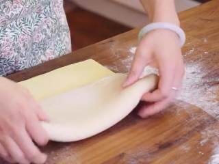 5、丹麦酥皮面包,把黄油片放在面片上，多出来的1/3面片往中间折，把剩下的连同黄油折上去