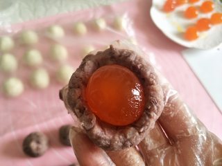 4、酥掉渣的蛋黄酥，月饼季做起来,醒好后的油皮和油酥，分割9份，继续覆盖保鲜膜，醒面。把豆沙分成9份，后包裹咸蛋黄，备用。