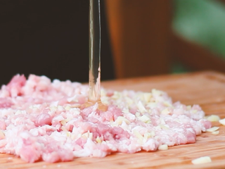 5、瑞典肉丸,姜姜、蒜放在猪肉中，打一个鸡蛋进去，剁匀，然后倒入容器内。