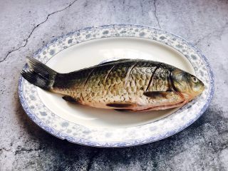 2、鲫鱼豆腐汤,把鱼的两面都切斜刀，在鱼的两面抹少许盐，腌制10分钟。