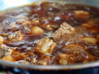 5、排骨面,再依次放入料酒,姜片,生抽,老抽和大量清水,大火烧开转小火慢炖。