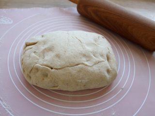 2、巧克力面包卷,案上撒些干粉，将面团倒入，轻轻地往中间团起来，蒙上保险膜，静置10分钟。