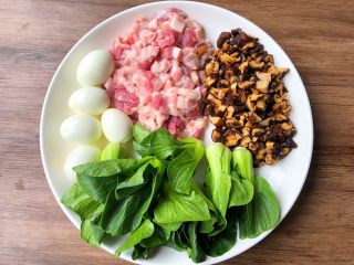 1、台式卤肉饭,首先把鸡蛋连壳放锅里煮熟，煮好剥掉外壳，五花肉清洗干净切成小块，干香菇提前泡发，泡发好清洗干净切成丁，小青菜清洗干净待用。