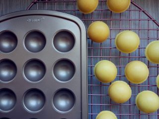 8、皮诺曹棒棒糖蛋糕,烤好后取出，轻轻颠动几下，取下上盖，再把模具倒扣一下，把球形的蛋糕都倒在晾网上晾凉