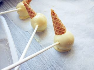 10、皮诺曹棒棒糖蛋糕,将脆皮甜筒的底部切下，趁巧克力尚未完全凝固，放在头部适当位置。