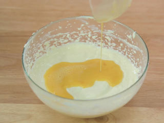 9、烤蓝莓重芝士蛋糕,第一次蛋液混匀之后再加入第二次的蛋液继续混匀，同样的混匀到看不见蛋液之后还是要用刮刀把边缘不均匀的芝士糊混进去拌匀