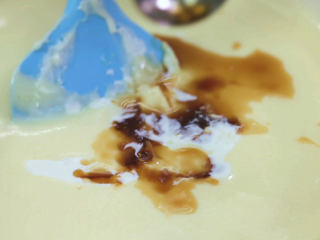 11、烤蓝莓重芝士蛋糕,然后加入淡奶油和香草精，用刮刀画圈圈拌匀，香草精重量比较少，我们可以用量勺或者随便倒一点，调味用的，厨房称最好买精算到0.1的厨房称，这样就可以称量了