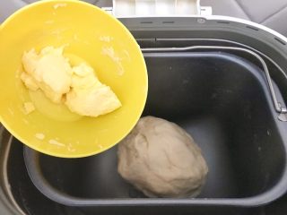 8、#家有烤箱#黑芝麻豆沙面包,当面包粉成团后，把黄油加进来，继续和面模式，