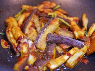 11、油淋茄子,放入白糖和黑胡椒粉翻炒均匀。
