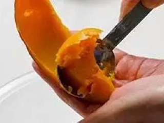 2、南瓜饼,用勺子将南瓜肉刮出。