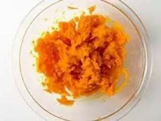 3、南瓜饼,放置在大碗中,趁热用勺子把南瓜撵成南瓜泥。