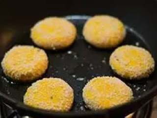 14、南瓜饼,平底锅中倒少许油,烧热后将南瓜饼放入。