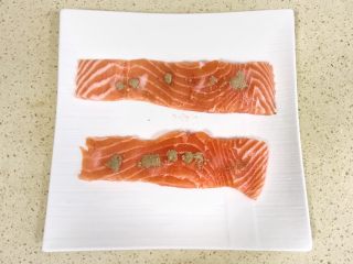 2、健康美味芦笋三文鱼,在三文鱼身上，撒上适量盐和黑胡椒粉