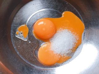 3、牛奶鸡蛋饼,在装有蛋黄的盆中加入绵白糖。