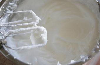 6、轻乳酪杯子蛋糕,蛋白中挤入柠檬汁，用电动打蛋器中速打发，其间分三次加入砂糖，将蛋白打至硬性发泡的程度，即拎起打蛋头其前端出现小三角。