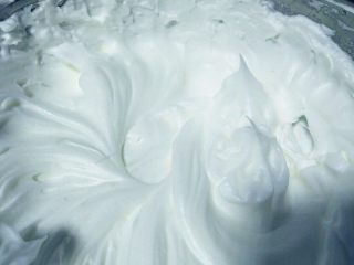 5、新手也能0失败——戚风蛋糕,分三次（鱼眼泡，明显花纹，大弯钩状态）加入辅料中的细砂糖，打发至硬性发泡状态。如图，停止打蛋器后，提起打蛋头，蛋白形成尖角状态。这个尖角可以