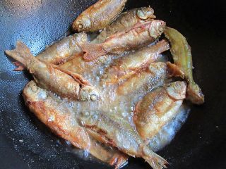 7、家乡特色美食——杂鱼炖小豆饼,热锅注入油烧至7成热，将过拿起摇晃一下，放入小鱼慢火煎