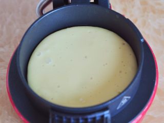 6、奶油松饼,将底部组件放下，舀一点面糊浇在底盘上，面糊会自动摊圆。