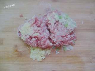 3、干炸肉丸子,把姜末葱沫和猪肉馅放在一起