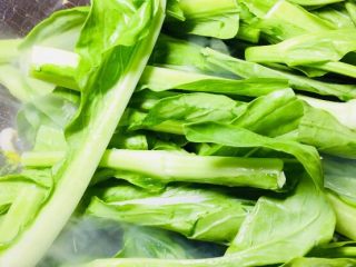 5、绿色美食蒜蓉菜苔,然后转大火放入菜苔！快速翻炒均匀！裹上猪油！