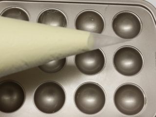 12、巧克力棒棒糖蛋糕,做好的面糊装在裱花袋里面，底下剪个口，再挤到棒棒糖模具里面