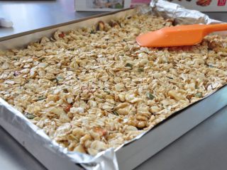 13、格兰诺拉麦片,将拌好的买片均匀铺平在烤盘上。