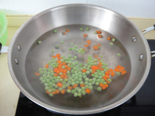 7、松仁鱼米,锅内水开后加入适量盐倒入青豆和胡萝卜丁焯水后捞起