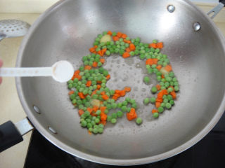 12、松仁鱼米,倒入青豆和胡萝卜丁加入适量盐煸炒均匀