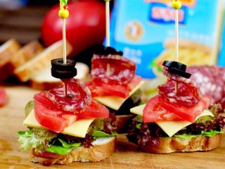 12、开放三明治,用竹签串上黑橄榄洋葱圈和萨拉米肠串在摆好的三明治上