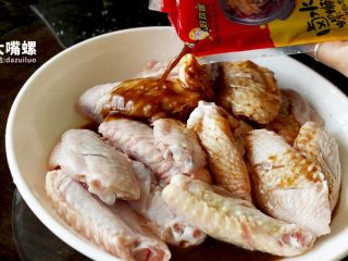 3、劲脆特制炸鸡翅丨大嘴螺,倒入万能的卤水和红油均匀搅拌,接下来给鸡翅按个摩吧