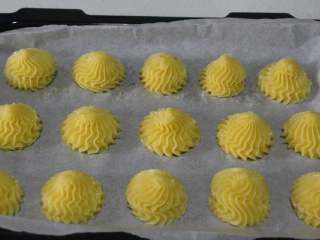 8、沙丁鱼咸奶油泡芙,把制作好的面糊转移到裱花袋中,用裱花嘴垂直挤出泡芙坯。