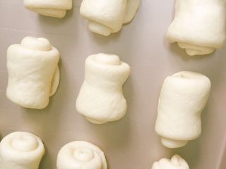 9、超级松软的牛奶小餐包,放入烤盘进行第二次发酵,35分钟左右!面团中间留一点空隙哦!家里没有合适的烤盘,我这个烤盘有点大了!