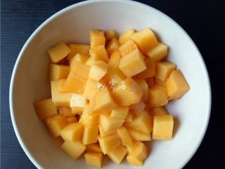 7、芒果西米露,两手捏住芒果两端,手指向上顶,将芒果肉翻出来,用刀刃贴着芒果皮削芒果肉,完整的芒果肉就切好了;