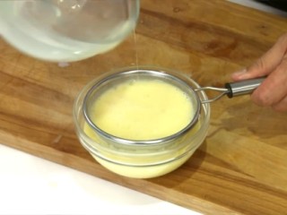 2、自製雞蛋豆腐,用濾網過濾後倒入模型容器中。