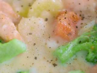 13、奶油炖菜,轻轻地翻动均匀，动作轻一点，不要把三文鱼碰碎了，加一点盐，现磨一些黑胡椒调味