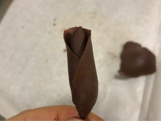 7、手工巧克力玫瑰花,再压一片裹在花芯上，花瓣的边缘可以用手再次捏薄，这样更逼真。