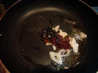 6、家常豆腐--挑逗你的味蕾,继续用刚刚煎豆腐的锅，不用再另外倒油了。放入切好的葱和蒜，再放一勺郫县豆瓣和1/2小勺豆豉，用小火炒香，炒出红油。