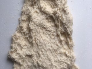3、培根芝士卷,将面团移到台面上，用搓的手法揉面，用右手手掌根将面团往前推，左手拿刮刀将推出去的面团重新刮到一起，重复这样的动作
