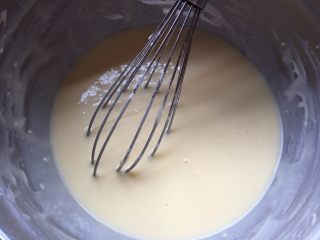 4、香草魔法蛋糕,剩余的240克牛奶和热水混合,成温热的牛奶液,分两次加入到蛋黄糊中,随后加入香草精,分别搅拌均匀