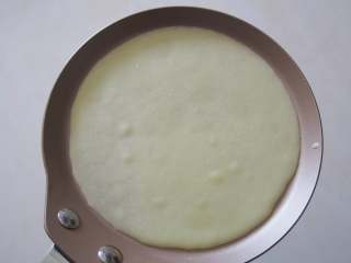 6、香蕉班戟卷,煎盘中加入一小勺面糊，小火加热至面糊微微鼓泡。