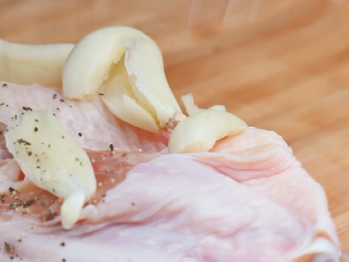 5、新奥尔良烤翅,鸡翅倒入容器内，放入蒜、孜然、奥尔良粉、胡椒粉，挤柠檬汁。